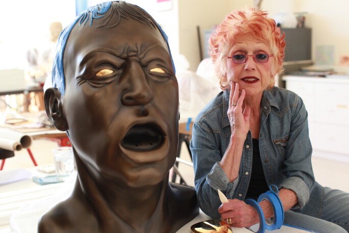 Artist Judy Chicago Poses With Her Piece Titled "Grand Bronze Head With Golden Tongue"