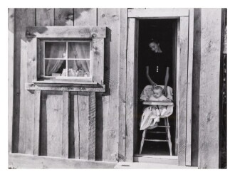 View 1 of Lot 324: Wife and baby of president of Ola self-help sawmill co-op in doorway of their home, Gem County, Idaho
