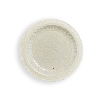 View 1 of Lot 5602: A Dingyao white-glazed moulded 'flower and rock' dish, Northern Song dynasty | 北宋 定窰白釉花石圖花口小盤