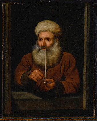 Catalog image of old man smoking a pipe, wearing a turban, half-length