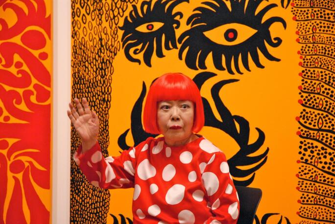 yayoi kusama waves to the press at tate modern