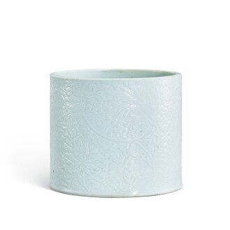View 1 of Lot 380: A carved white-glazed 'lotus' brushpot, Qing dynasty, Kangxi period 清康熙 白釉刻纏枝蓮紋筆筒 《成化年製》仿款