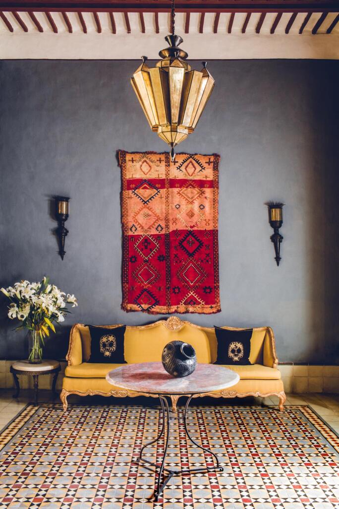 Rug hanging on wall behind sofa, photo by Matthieu Salvaing