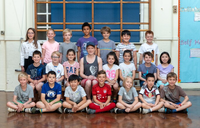 Three rows of school children sitting and standing for their class photo