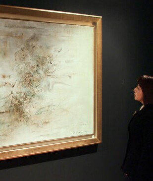 woman standing in front of zao wou ki's abstract painting
