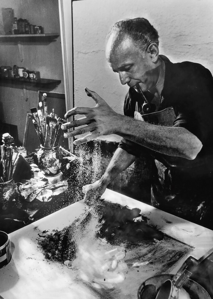 Abstract painter Enrico Donati working w. dust, auto paint, pipe ashes, etc. to create one of his paintings.