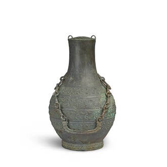 View 1 of Lot 18: An archaic bronze wine vessel and cover (Hu), Eastern Zhou dynasty, Warring States period | 東周 戰國 青銅卷龍紋鋪首耳壺